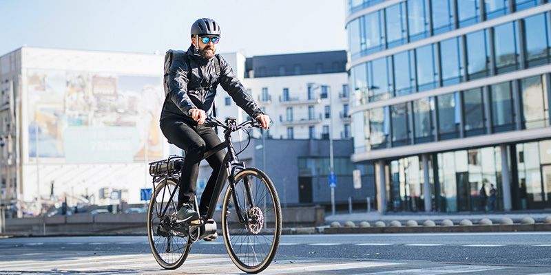 Fahrradfahrer fährt in der Stadt mit Fahrradhelm